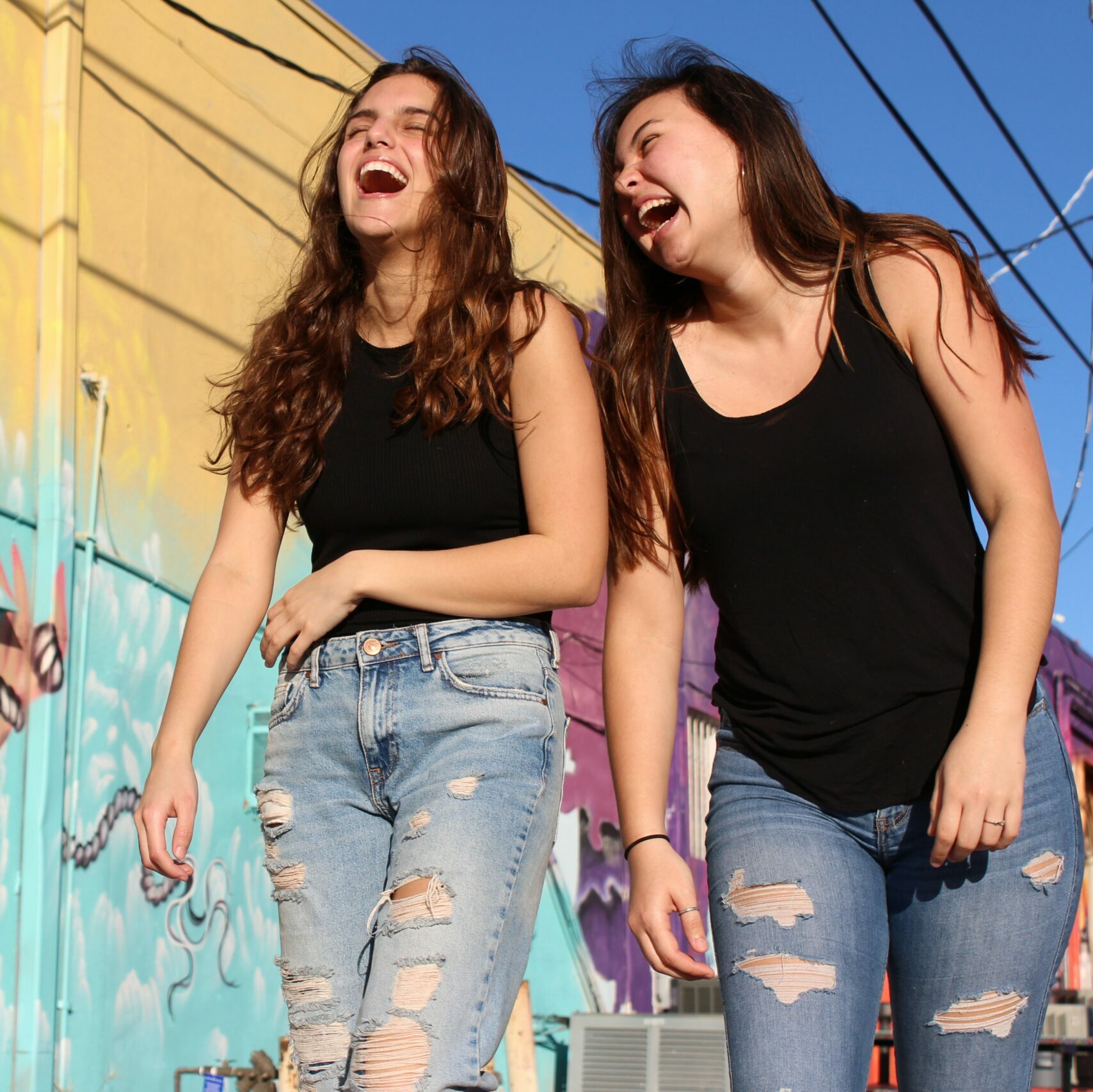 photo of two laughing women walking past graffiti wall 2346701 scaled e1647609357519